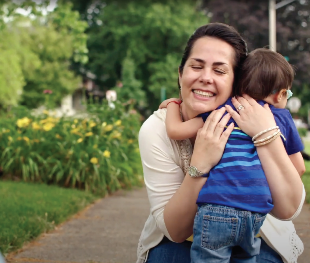 mother holding her son tightly playing outside